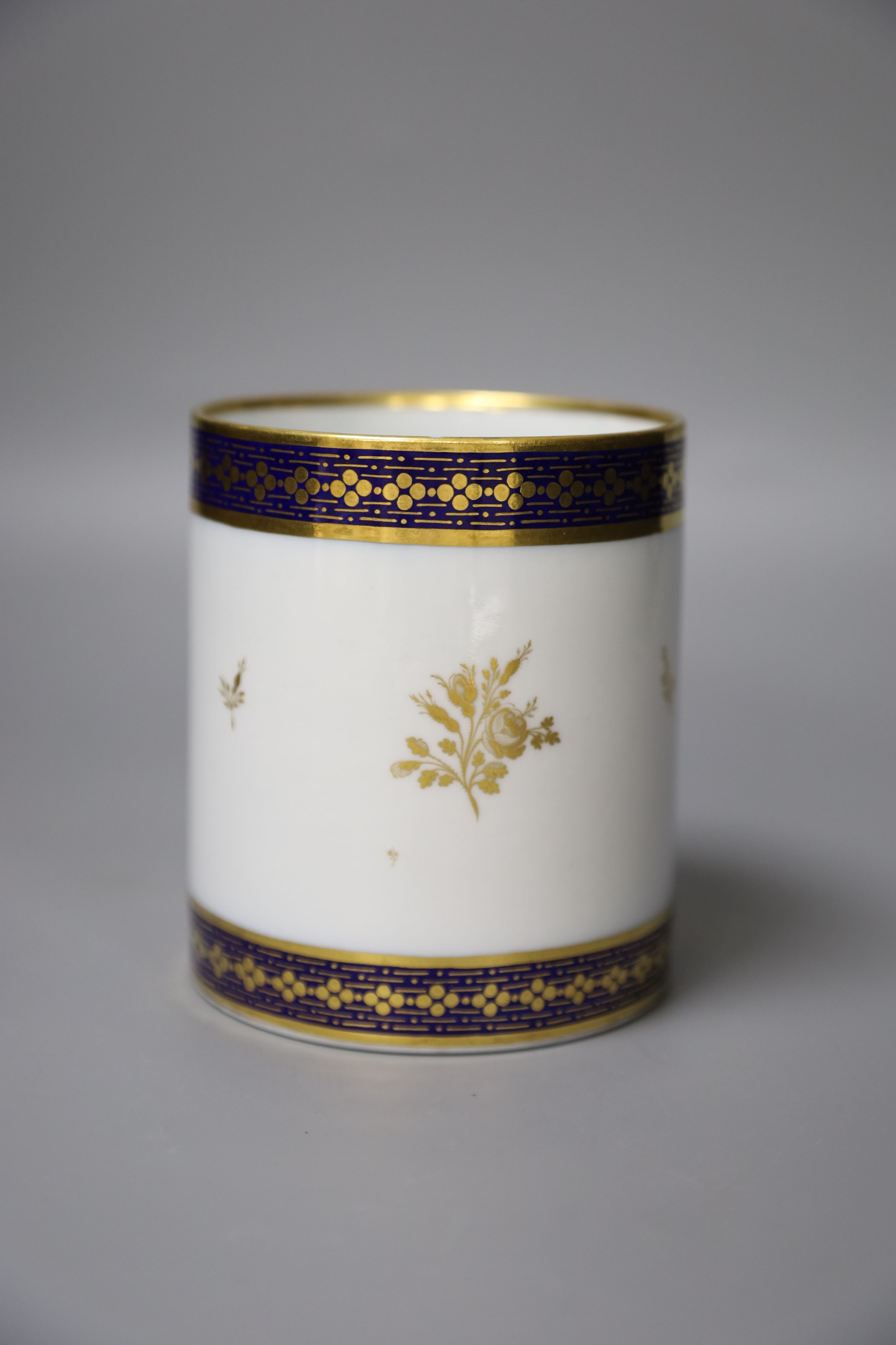 A 19th century Barr Worcester fine mug with a distinctive handle painted in under glaze blue and gilded with floral sprays, height 11cm